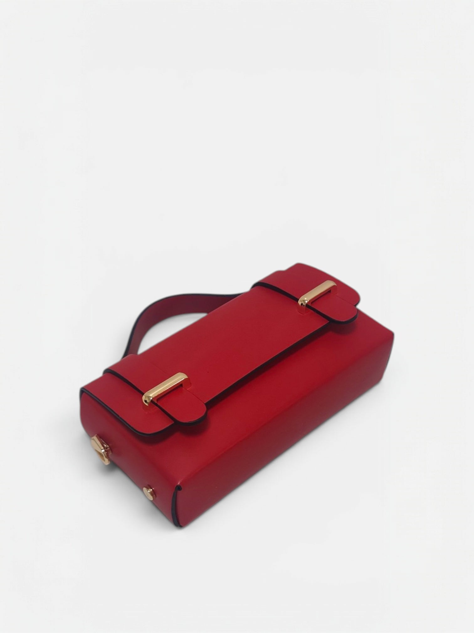 Borsetta a mano mini in vera pelle color rosso appoggiata su superficie